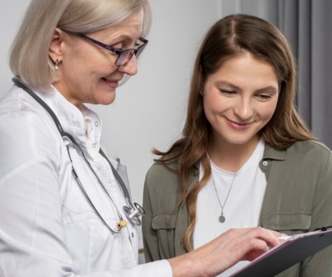 Médica explicando a una paciente los pasos del procedimiento de histerosalpingografía para evaluar la salud reproductiva.