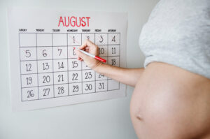 Mujer frente a calendario evaluando su embarazo semana a semana.